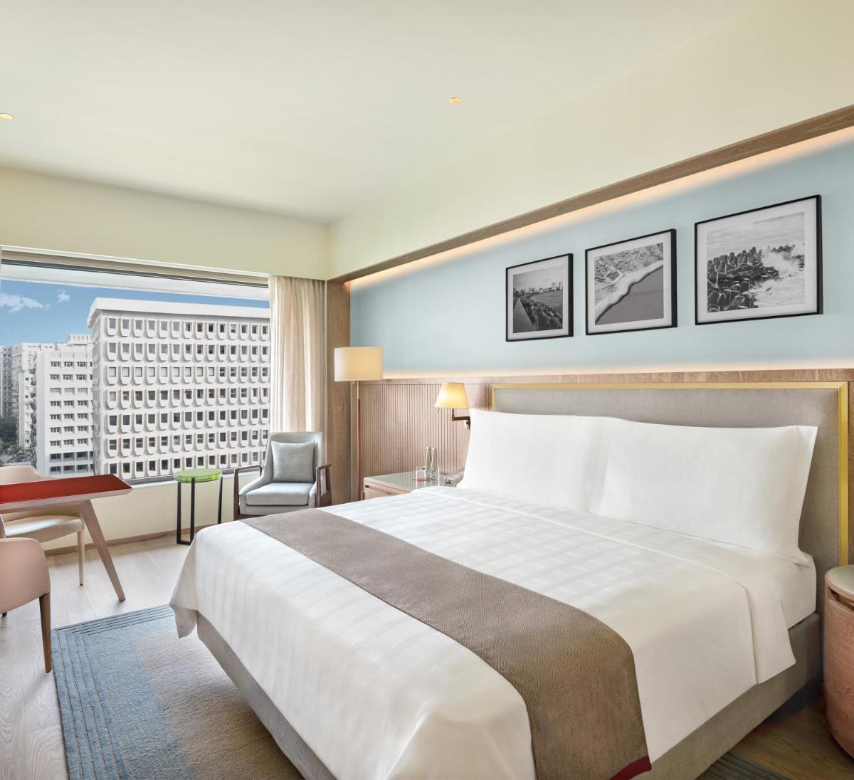 a hotel room with a large bed and a desk at Trident Nariman Point in Mumbai