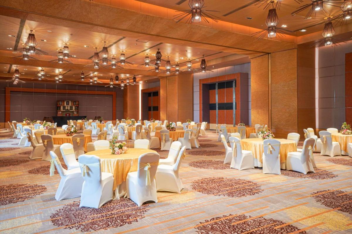 a large banquet hall with tables and white chairs at Radisson Blu Hotel Amritsar in Amritsar
