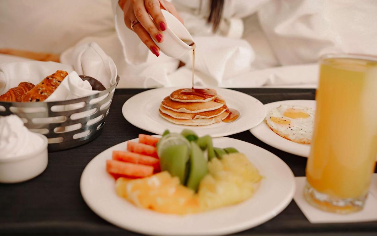 a person is drizzling syrup onto plates of food at Radisson Blu Hotel Amritsar in Amritsar