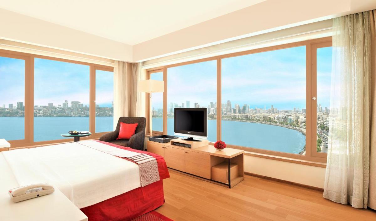 a hotel room with a bed and a large window at Trident Nariman Point in Mumbai a hotel room with a bed and a large window at Trident Nariman Point in Mumbai