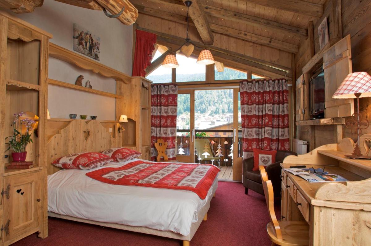 une chambre avec un lit et un bureau dans une pièce dans l'établissement Hotel L'Equipe, à Morzine