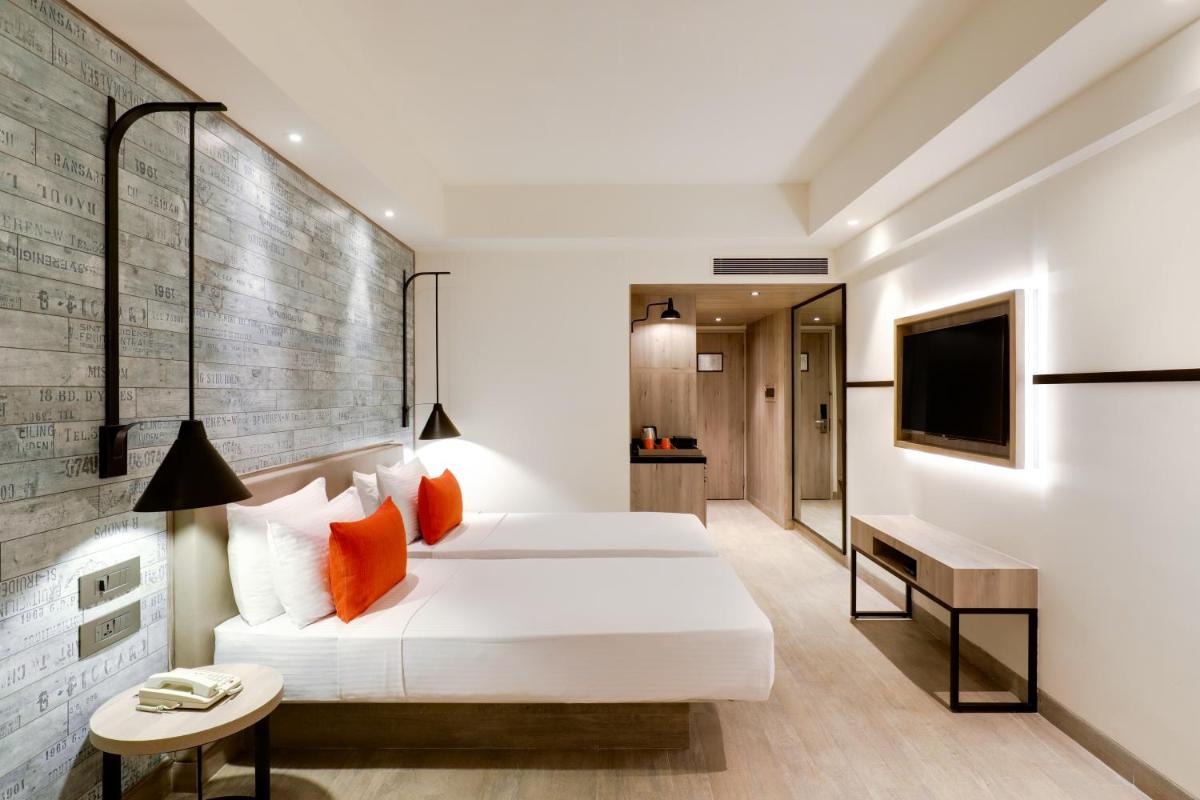 a hotel room with a bed and a television at Lemon Tree Premier, Mumbai International Airport in Mumbai