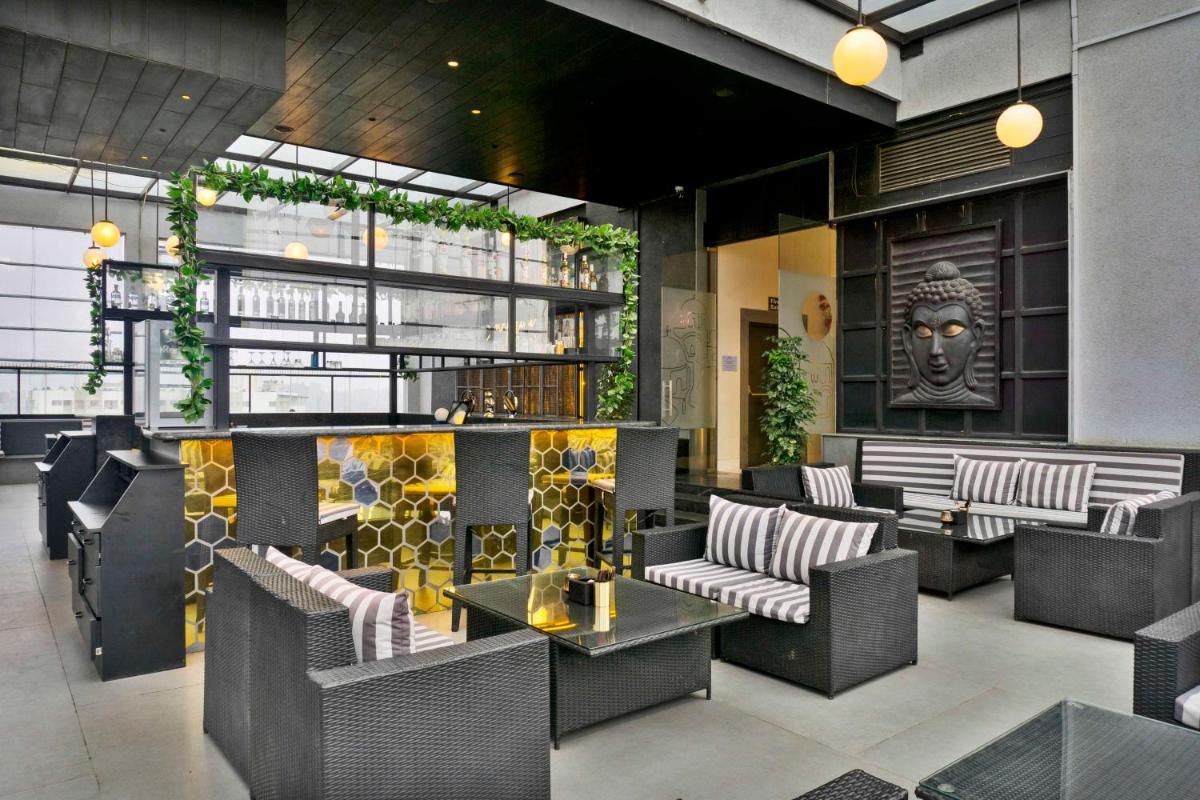 a lobby with couches and tables in a building at Hilton Garden Inn Pune Hinjawadi in Pune