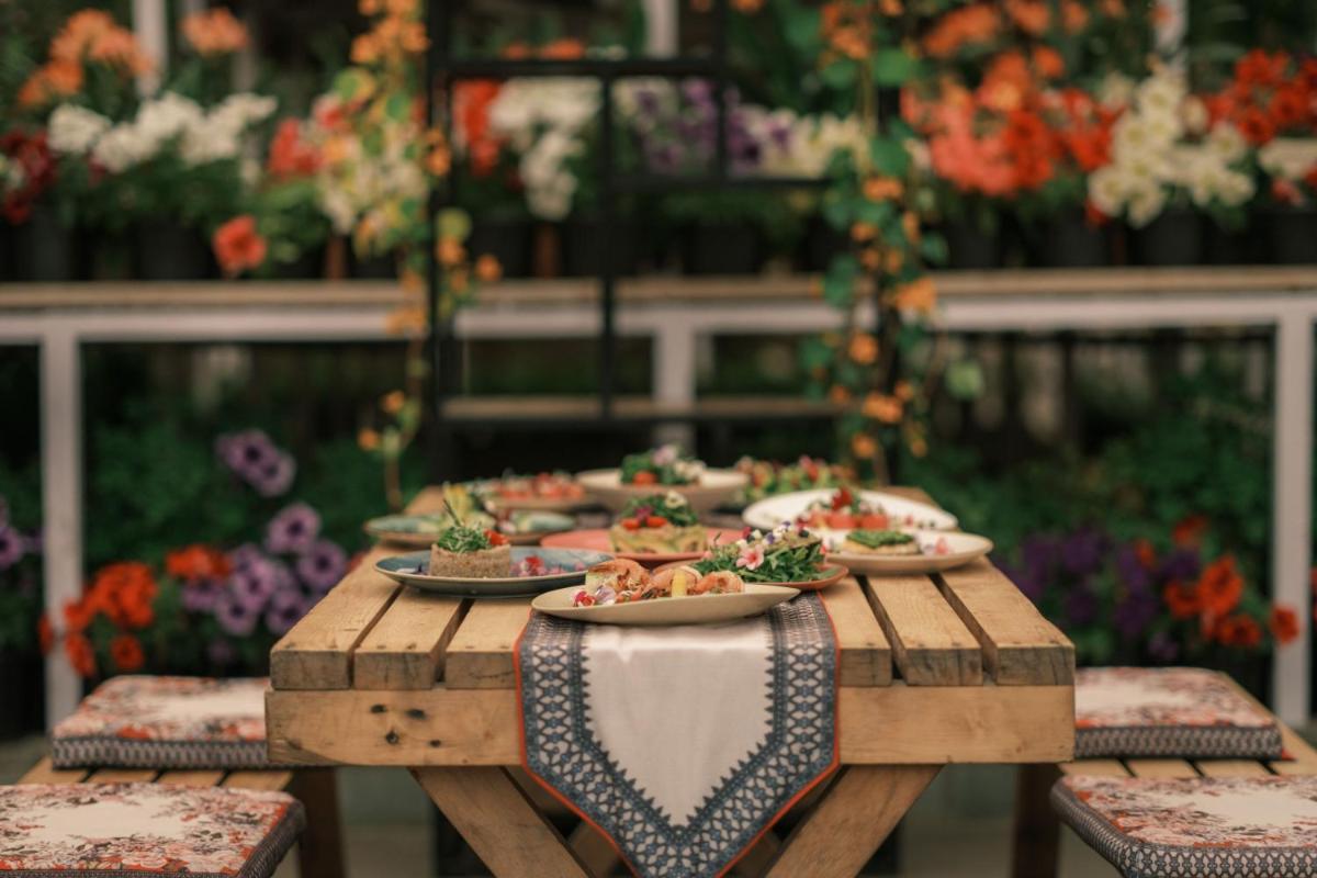 a wooden table with plates of food on it at JW Marriott Mussoorie Walnut Grove Resort & Spa in Mussoorie