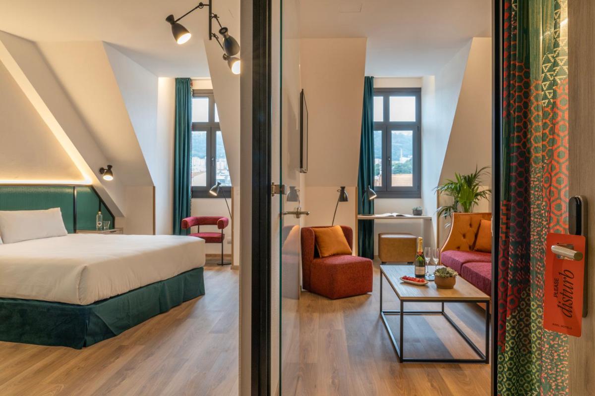Un dormitorio con una cama y una sala de estar. en Axel Hotel Bilbao - Adults Only, en Bilbao