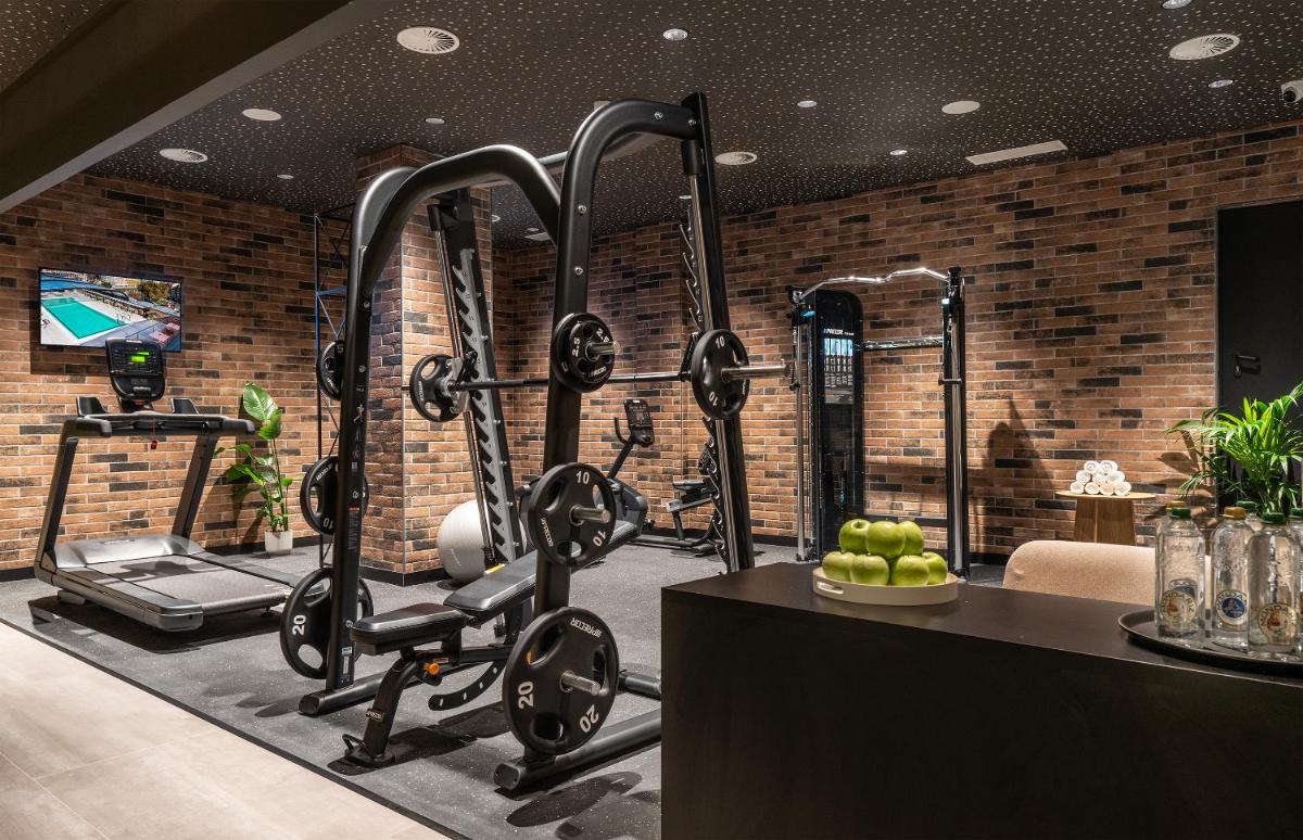 un gimnasio con varias cintas de correr y una cinta de correr en Axel Hotel Bilbao - Adults Only, en Bilbao