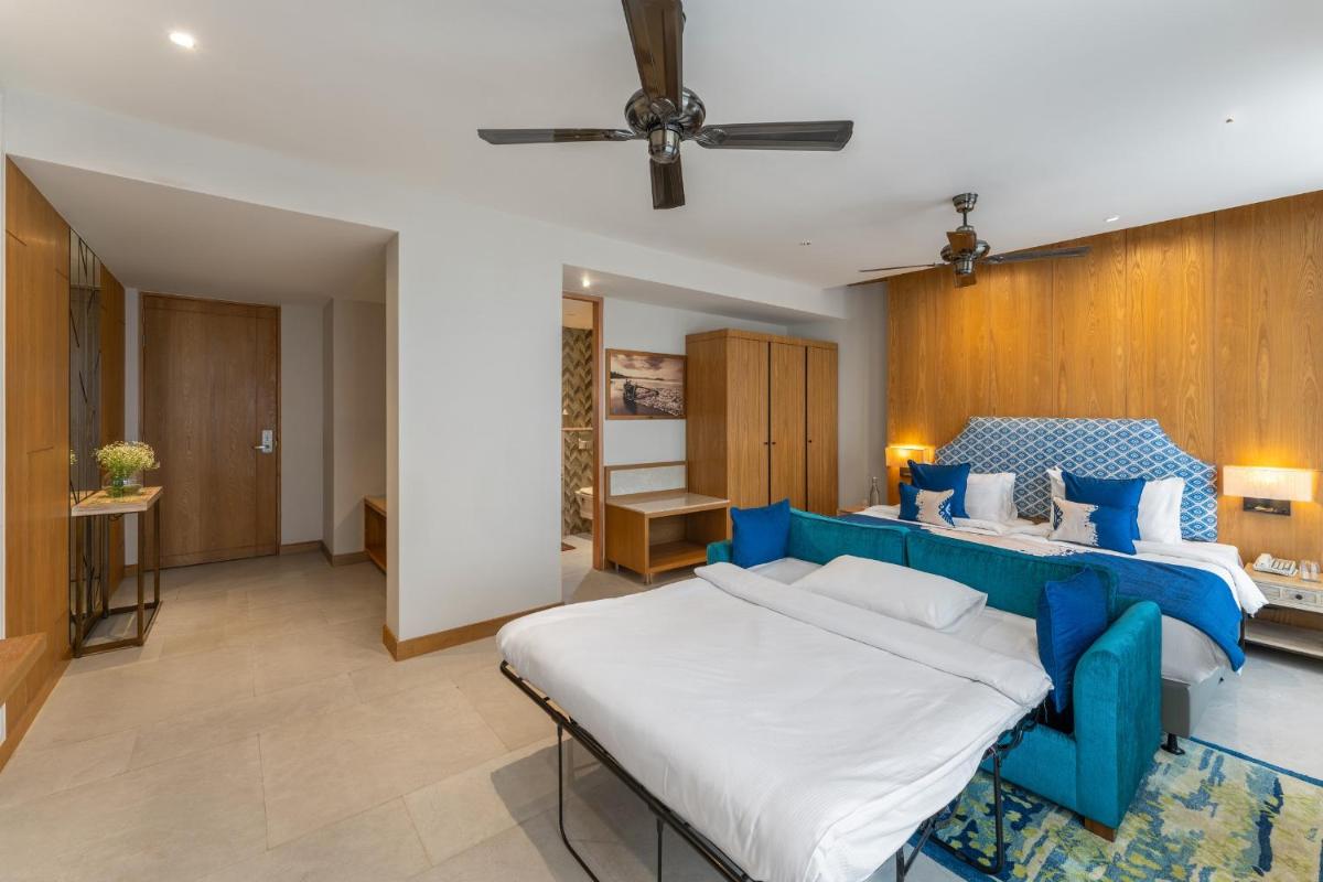 a bedroom with a blue bed in a room at The Astor - All Suites Hotel Candolim Goa in Candolim a bedroom with a blue bed in a room at The Astor - All Suites Hotel Candolim Goa in Candolim
