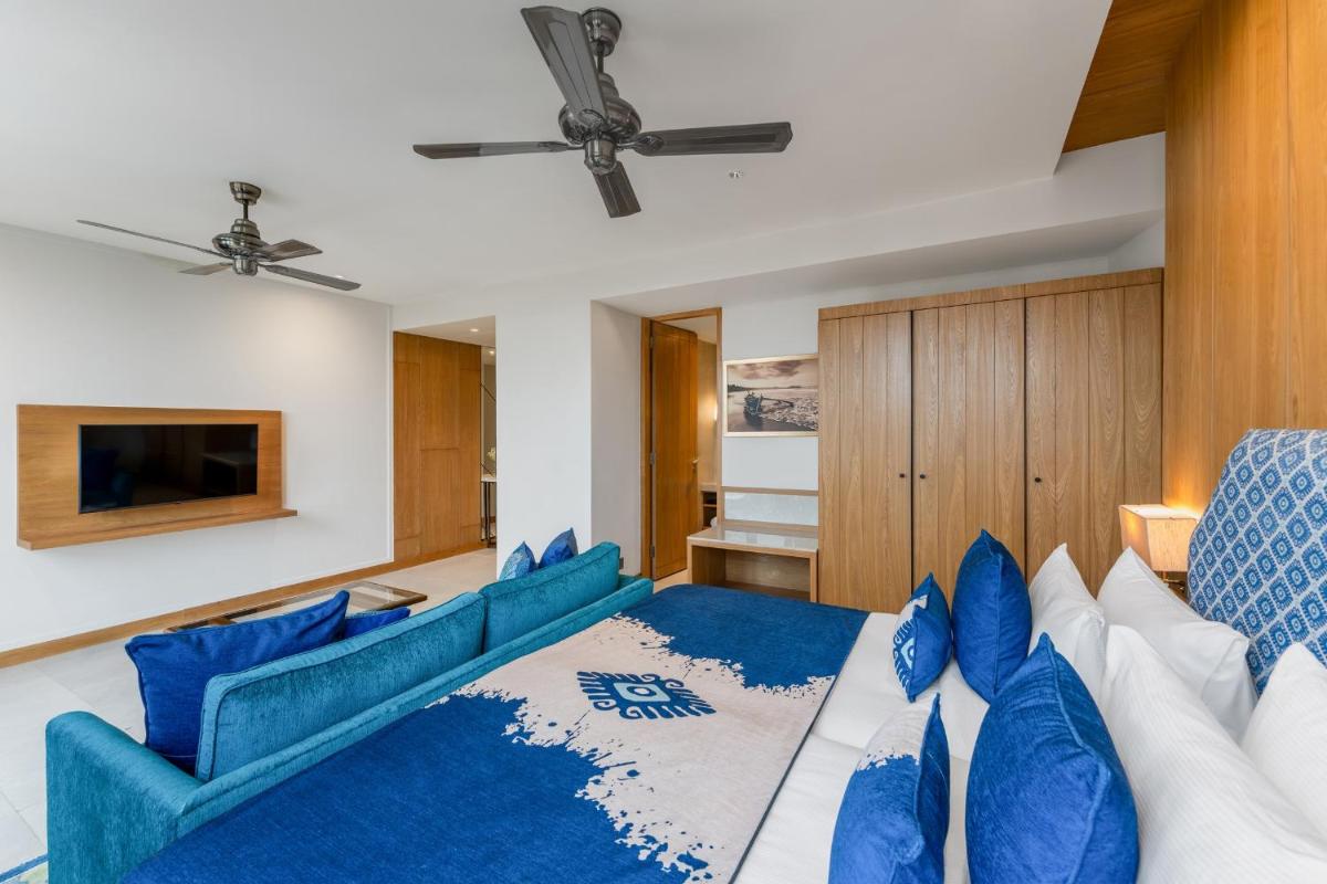 a living room with blue and white furniture at The Astor - All Suites Hotel Candolim Goa in Candolim a living room with blue and white furniture at The Astor - All Suites Hotel Candolim Goa in Candolim