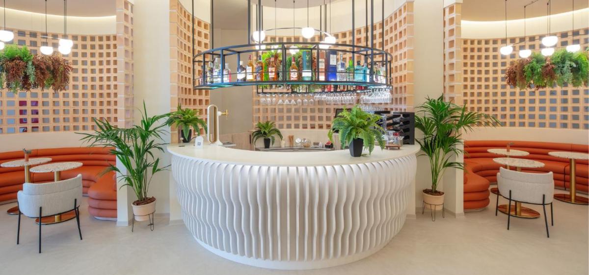 un restaurante con una gran barra blanca y plantas en RH Silene Hotel & Spa 4 Sup, en Castellón de la Plana