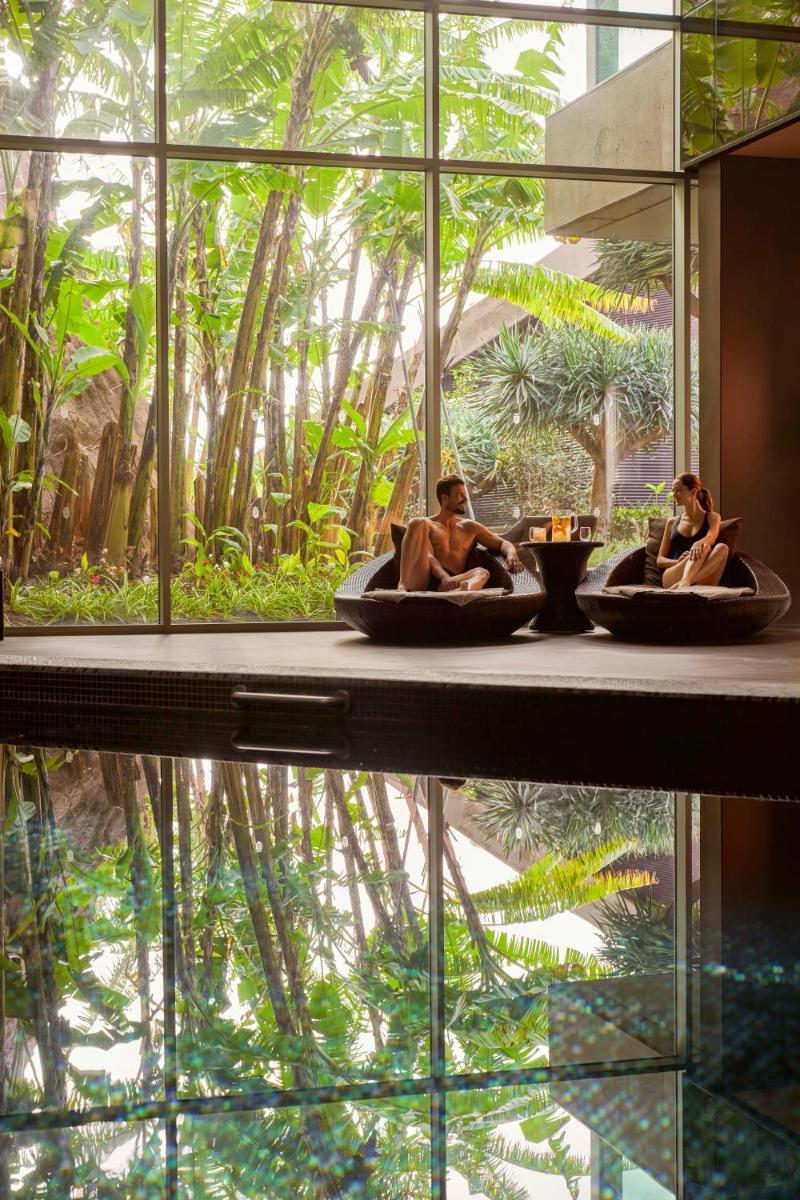 dois homens em banheiras num quarto com uma grande janela em Saccharum - Resort and Spa - Savoy Signature na Calheta