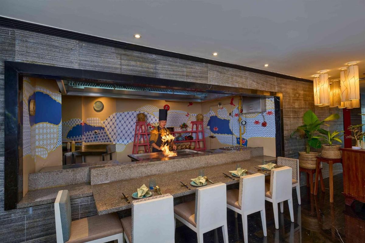 a restaurant with a table and chairs and a fireplace at Crowne Plaza Kochi by IHG in Cochin