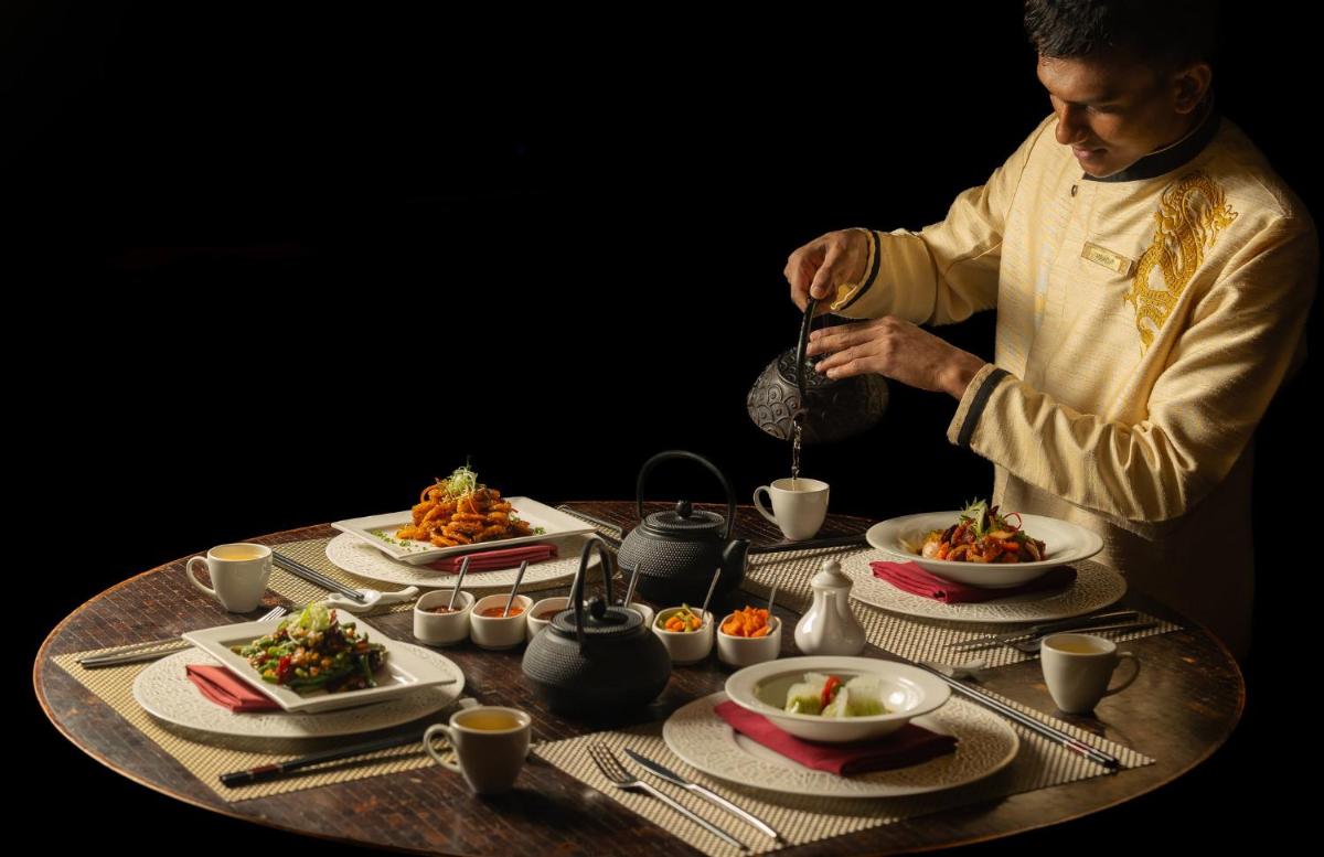 a man preparing food on a table with plates of food at InterContinental Jaipur Tonk Road by IHG in Jaipur