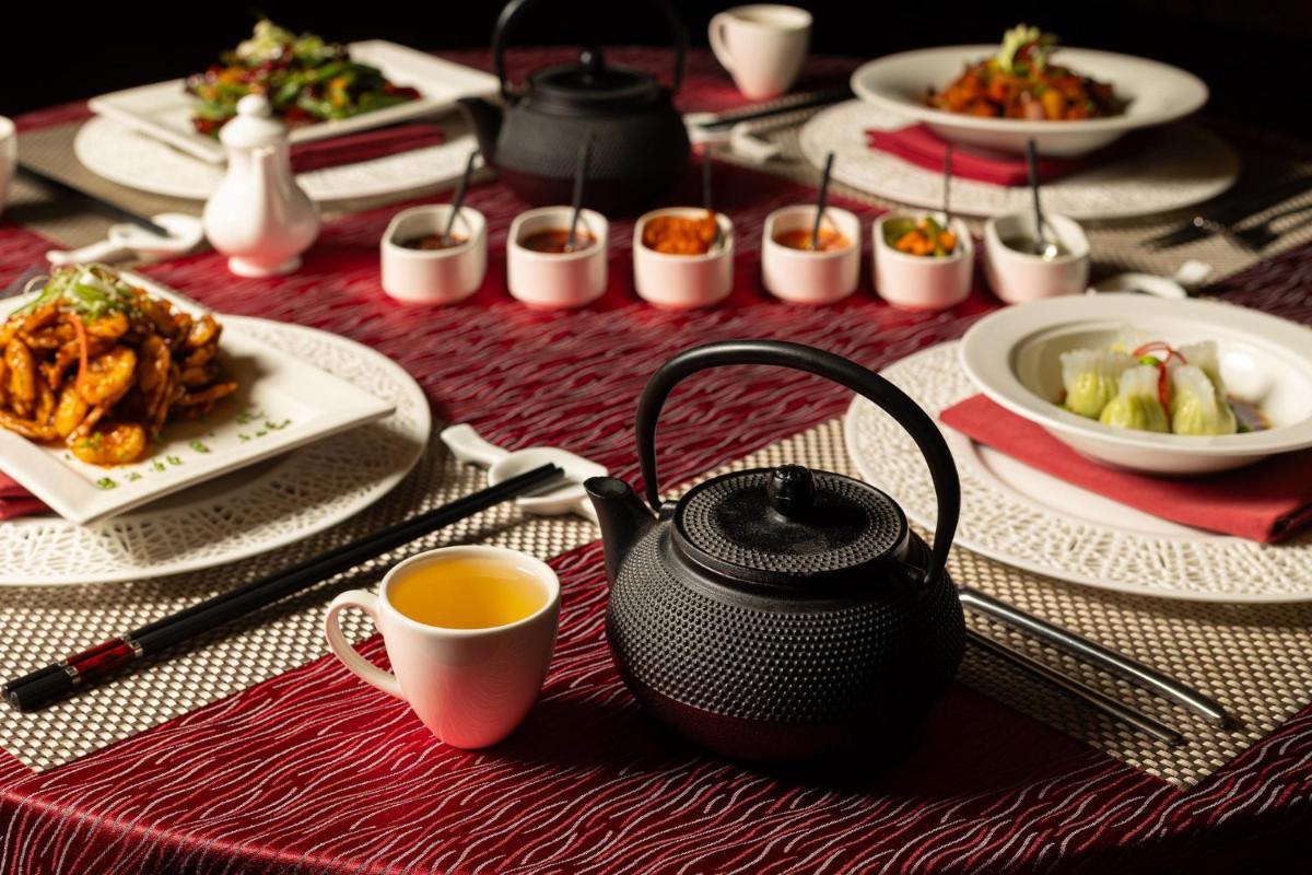 a table with a tea pot and plates of food at InterContinental Jaipur Tonk Road by IHG in Jaipur
