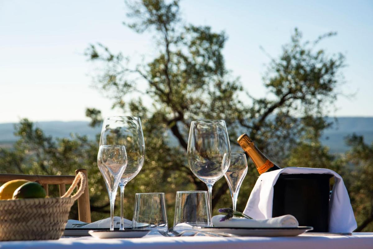 una mesa con copas y una botella de vino en Hábitat Cigüeña Negra, en Valverde del Fresno