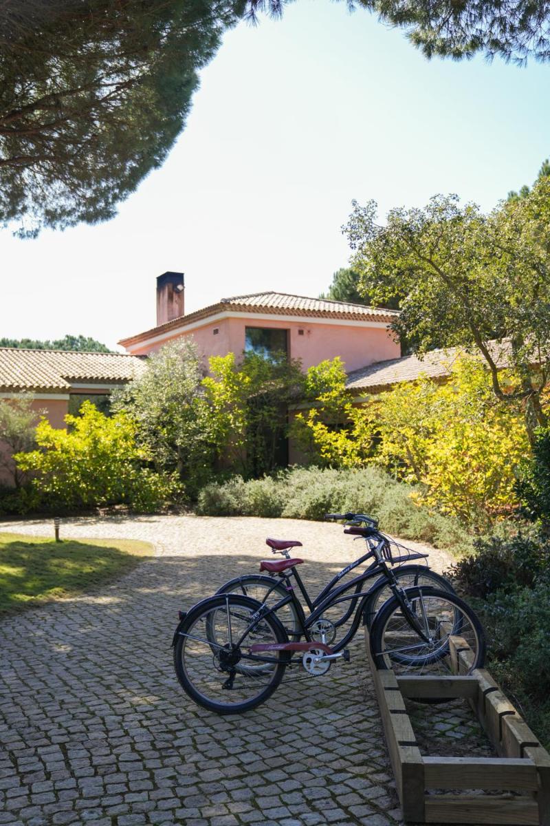 uma bicicleta está estacionada numa calçada de tijolos em Sublime Comporta Country Retreat & SPA na Comporta