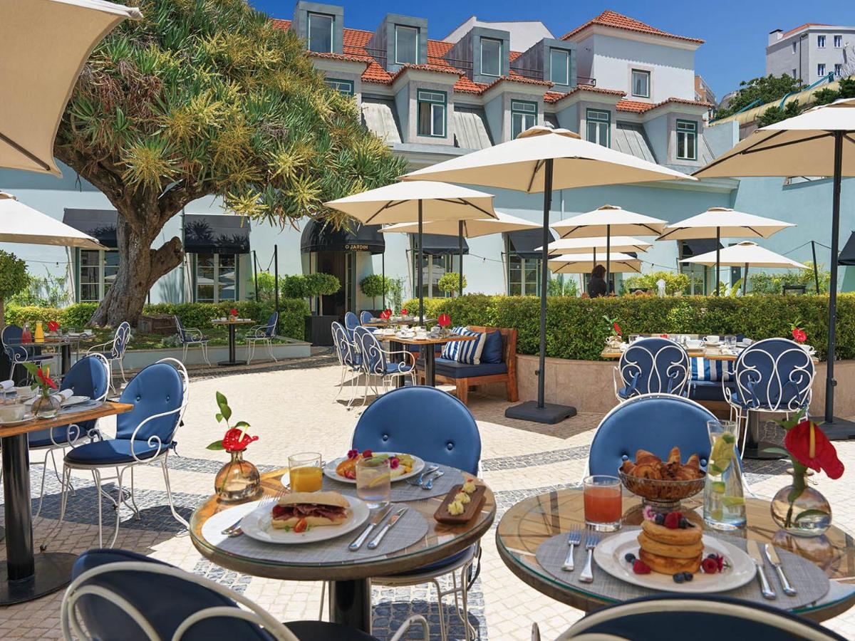 um pátio ao ar livre com mesas e cadeiras com comida em The One Palácio da Anunciada em Lisboa