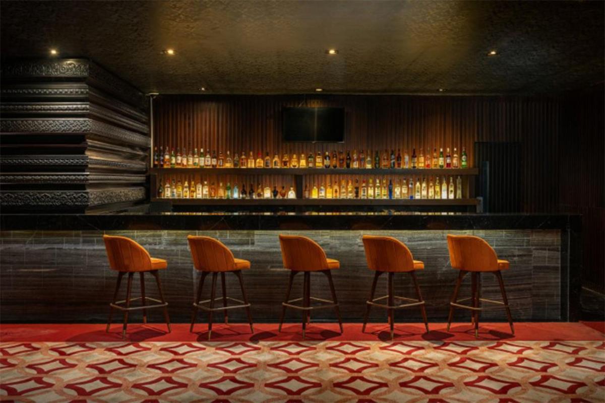 a bar with orange chairs in a room at Crowne Plaza Kochi by IHG in Cochin