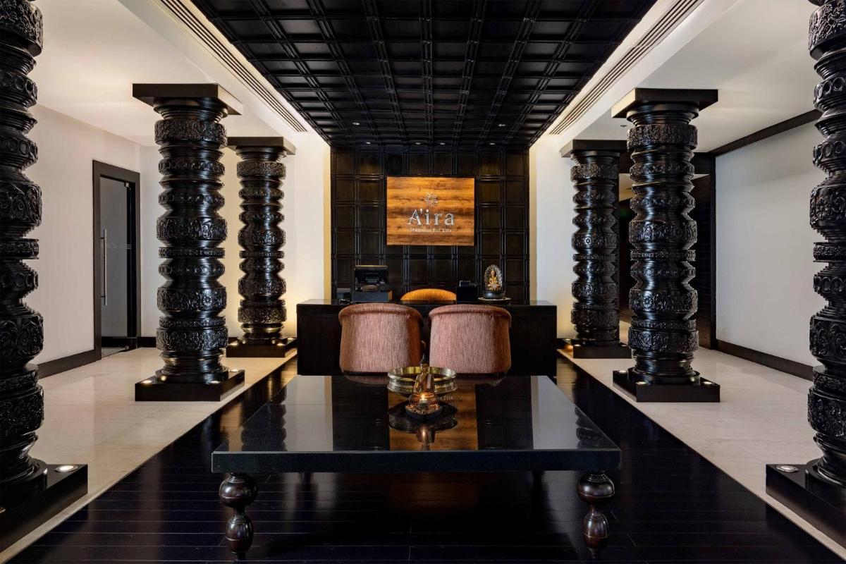 a lobby with columns and a couch and a table at Crowne Plaza Kochi by IHG in Cochin