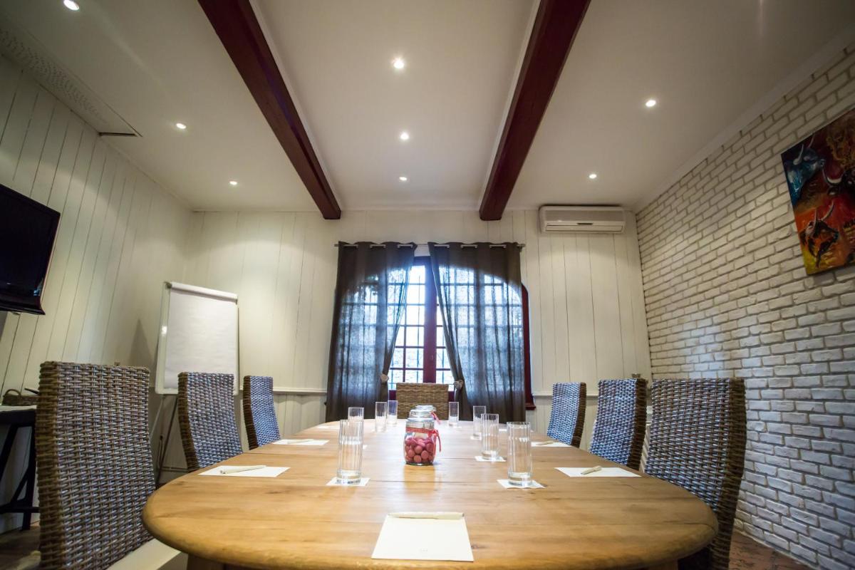une salle de conférence avec une grande table en bois et des chaises dans l'établissement La Regalido, à Fontvieille 118 autres photos