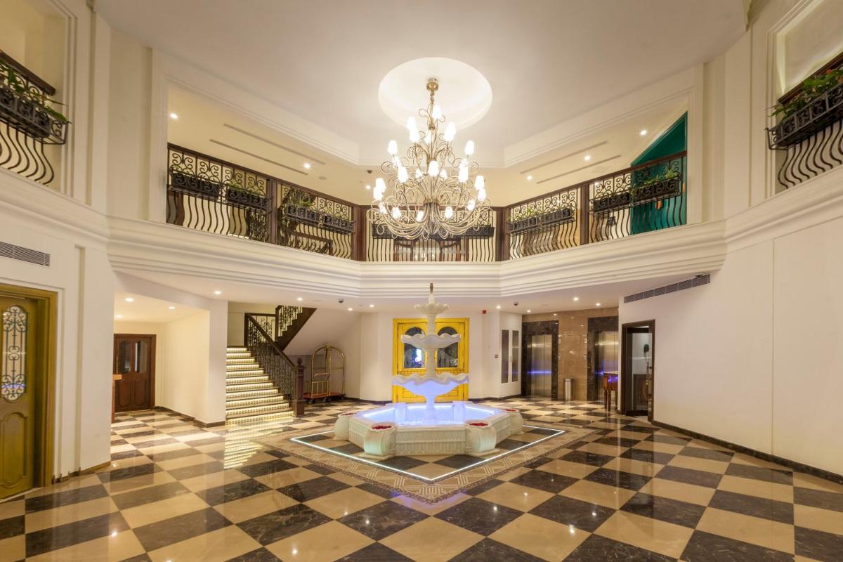 a large room with a bed and a chandelier at Fragrant Nature Kochi - A Five star Classified Hotel in Cochin