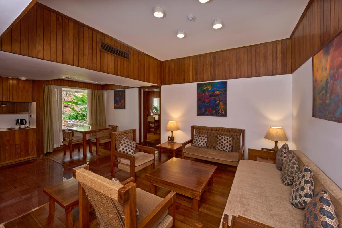 a living room with wooden walls and wooden furniture at Casino Hotel - CGH Earth, Cochin in Cochin