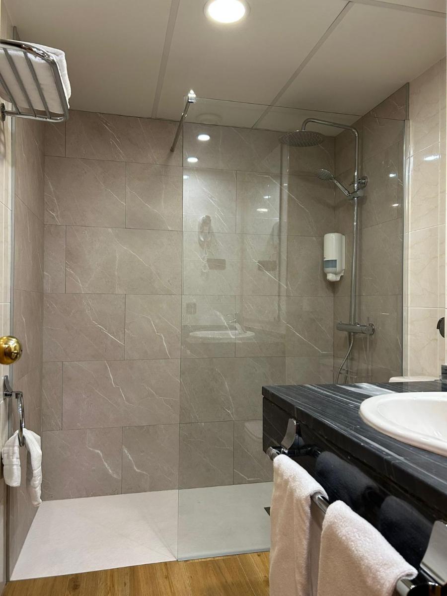 Un baño con ducha de cristal y lavabo. en Hotel Eth Solan & SPA, en Vielha 61 fotos más