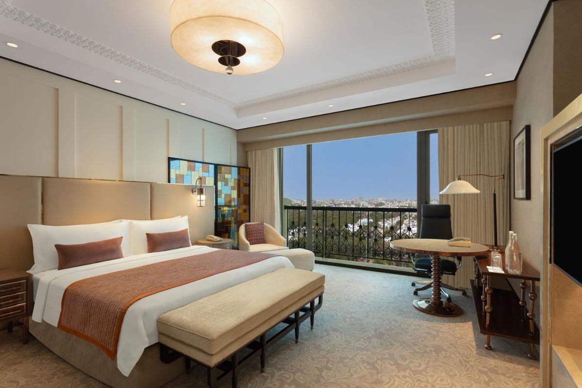 a bedroom with a large bed and a balcony at ITC Narmada, a Luxury Collection Hotel, Ahmedabad in Ahmedabad