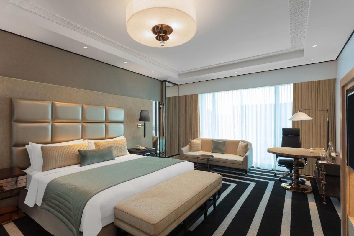 a large bedroom with a large bed and a desk at ITC Narmada, a Luxury Collection Hotel, Ahmedabad in Ahmedabad