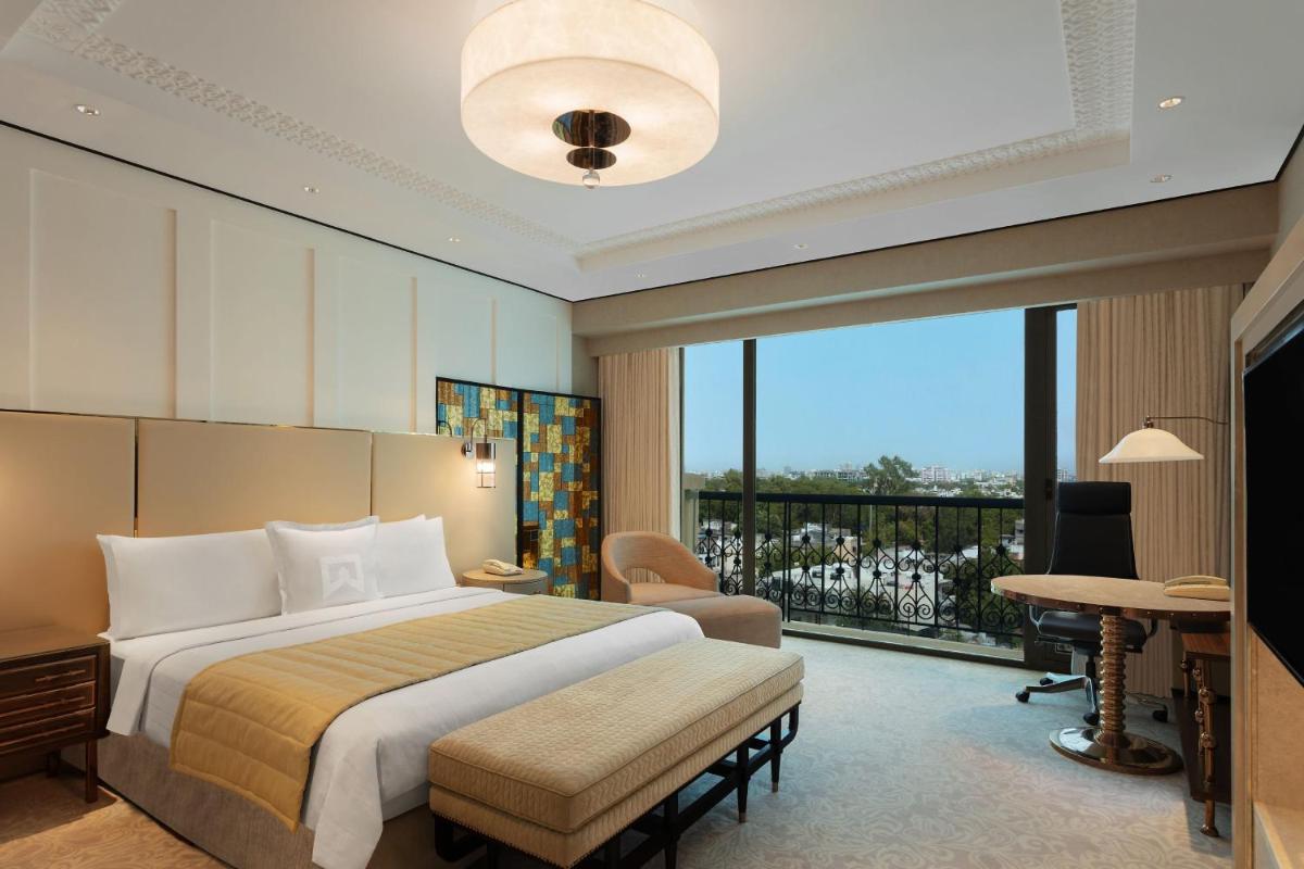 a hotel room with a bed and a balcony at ITC Narmada, a Luxury Collection Hotel, Ahmedabad in Ahmedabad