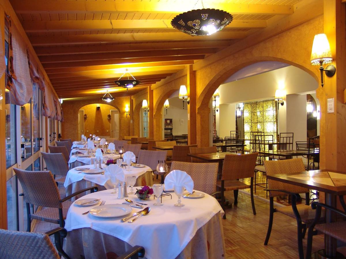 uma sala de jantar com mesas e cadeiras com toalha de mesa branca em Cerro Da Marina Hotel - Adults Only em Albufeira
