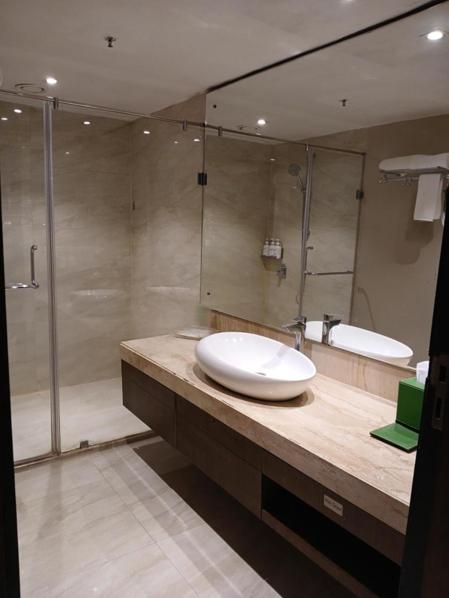 a bathroom with a sink and a shower at Holiday Inn Kolkata Airport by IHG in Kolkata