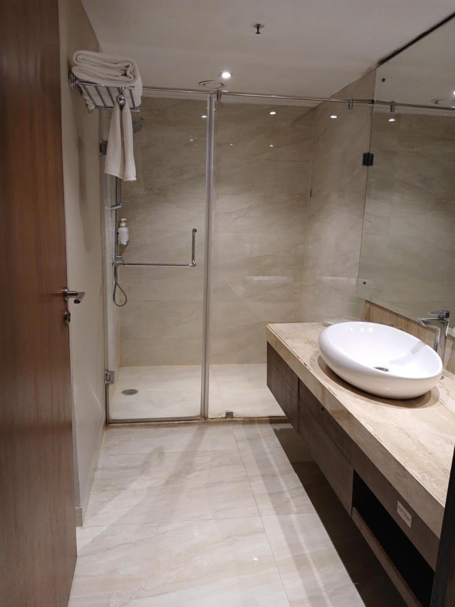 a bathroom with a shower and a white sink at Holiday Inn Kolkata Airport by IHG in Kolkata