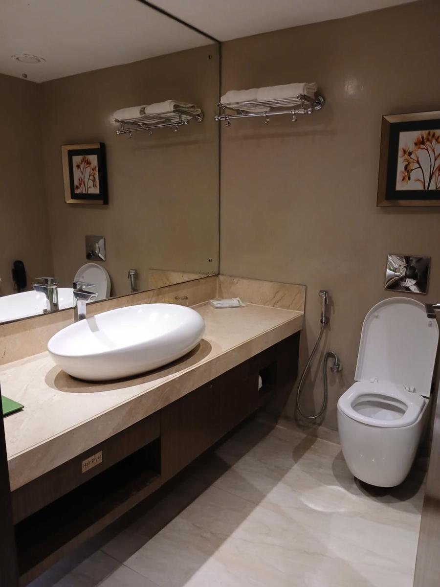a bathroom with a sink and a toilet at Holiday Inn Kolkata Airport by IHG in Kolkata