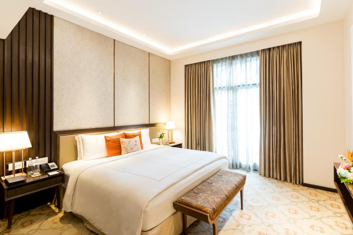 a hotel room with a large bed and a window at Taj Mahal Lucknow in Lucknow