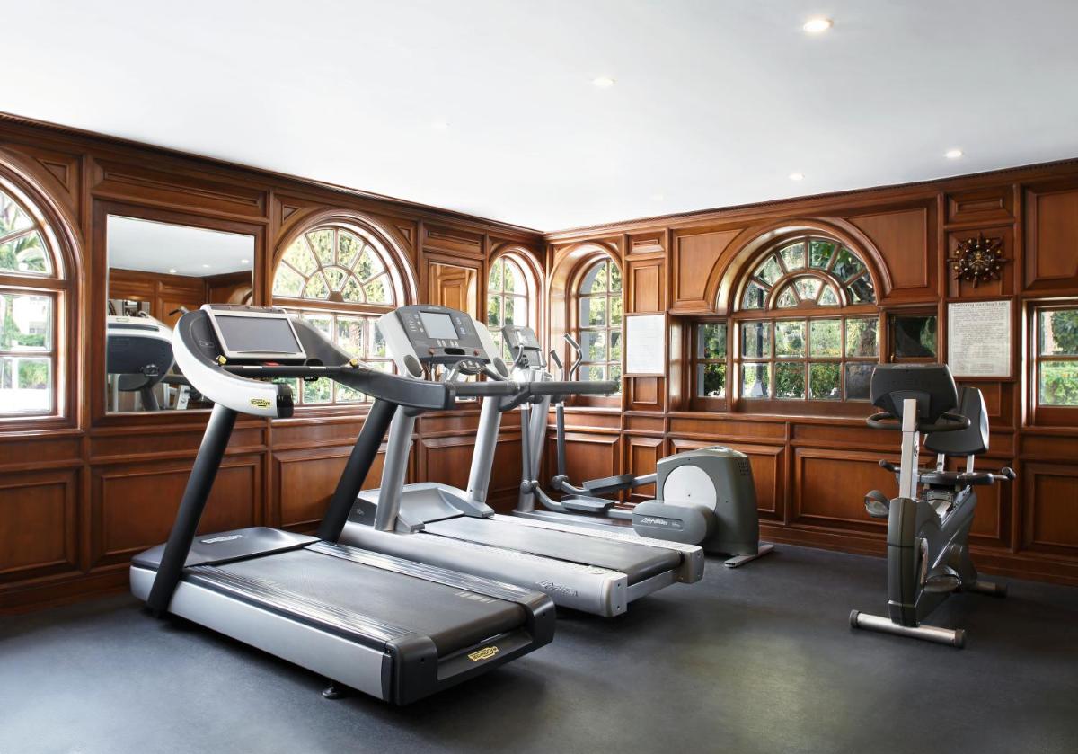 a gym with wood paneling and tread machines in a room at Taj Mahal Lucknow in Lucknow