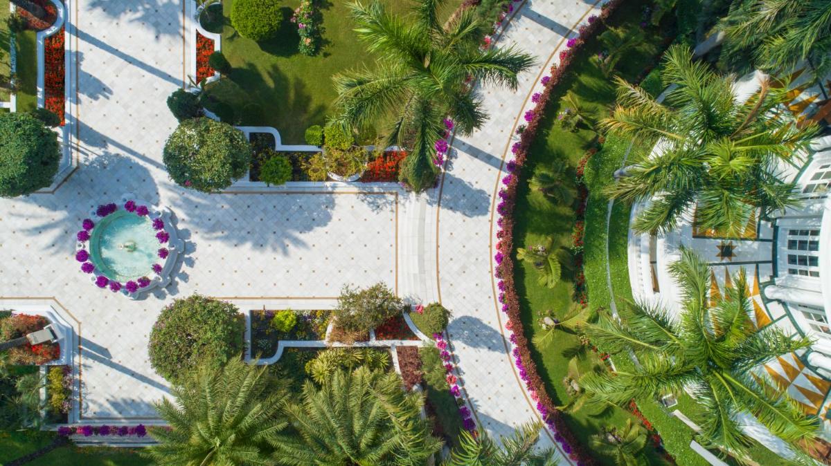 an overhead view of a park with palm trees and a pool at Taj Mahal Lucknow in Lucknow