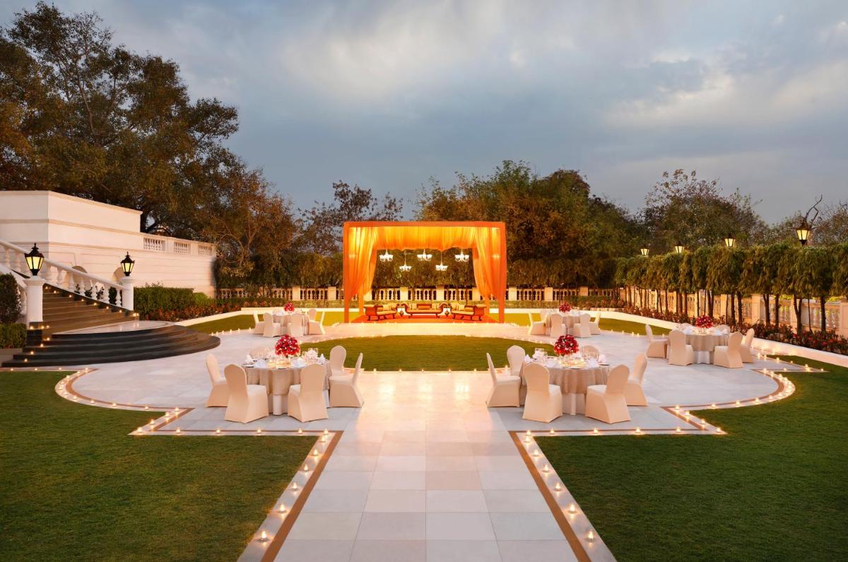 a garden with white tables and chairs and a marquee at Taj Mahal Lucknow in Lucknow