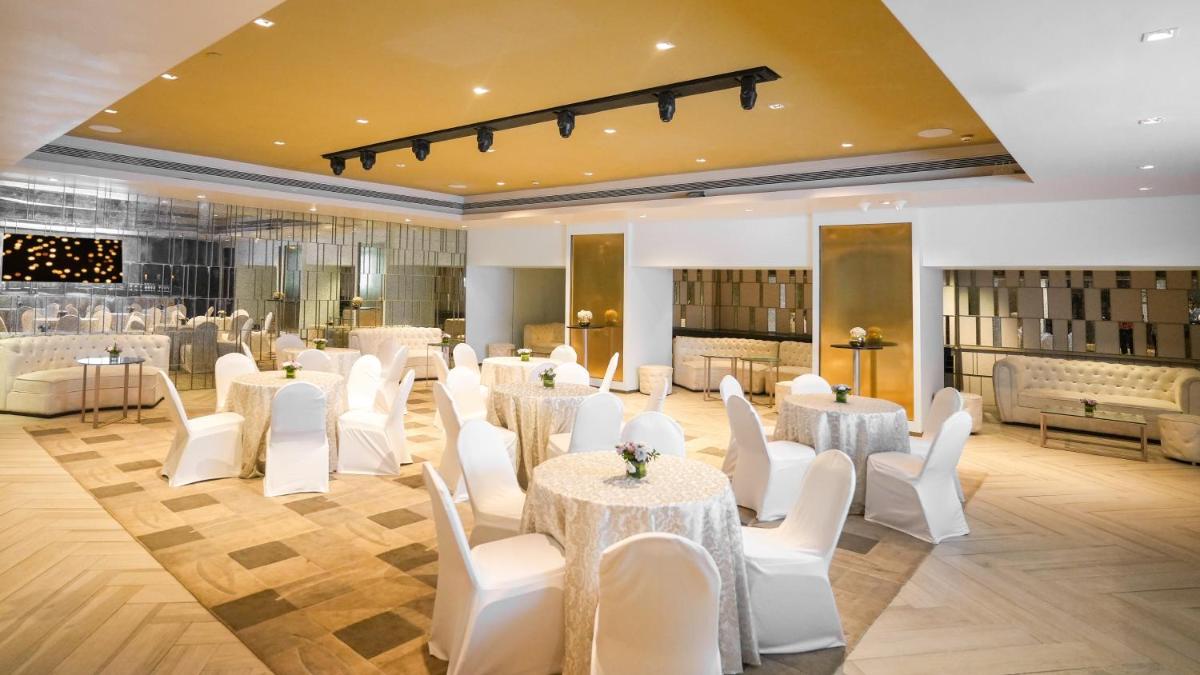 a room with white tables and white chairs in a room at InterContinental Marine Drive Mumbai by IHG in Mumbai