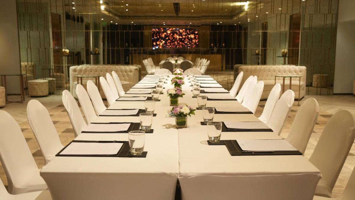 a long table with white tables and white chairs at InterContinental Marine Drive Mumbai by IHG in Mumbai