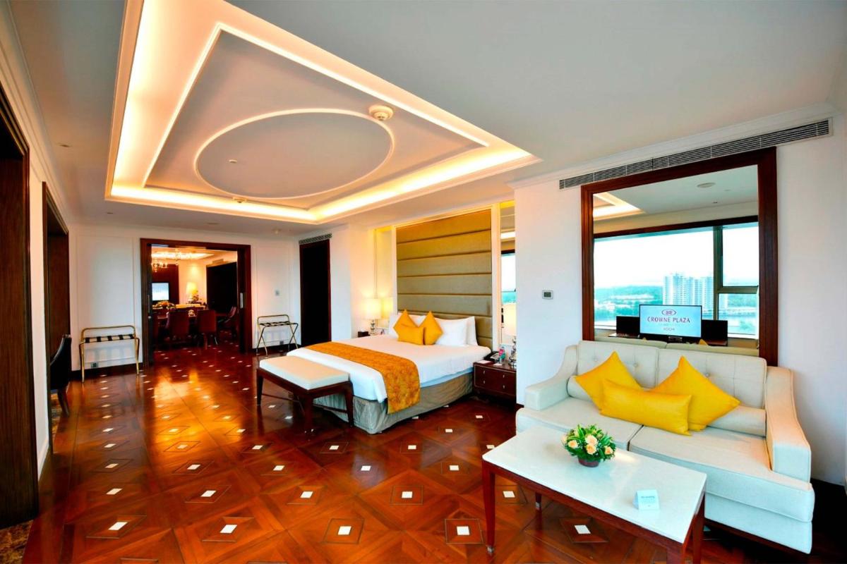 a hotel room with a bed and a couch at Crowne Plaza Kochi by IHG in Cochin