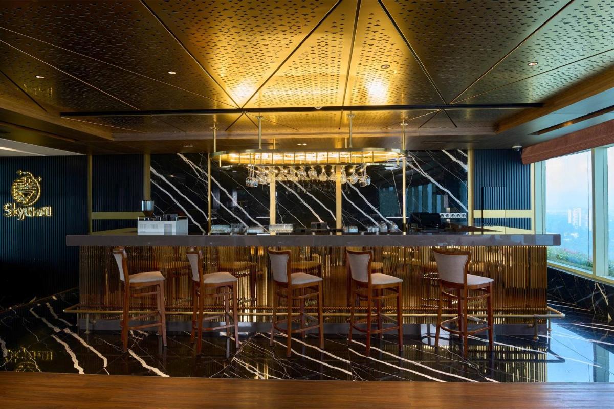 a bar with stools in a restaurant with a view at Crowne Plaza Kochi by IHG in Cochin