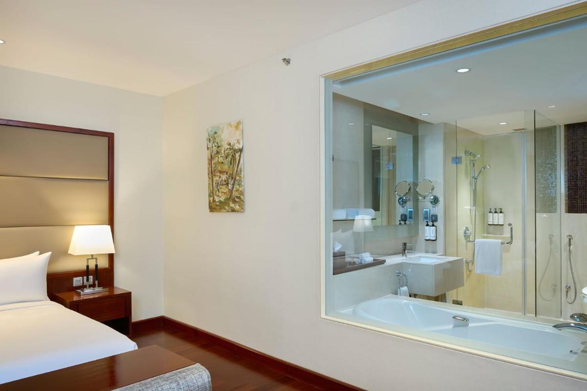 a hotel room with a tub and a bed at Crowne Plaza Kochi by IHG in Cochin