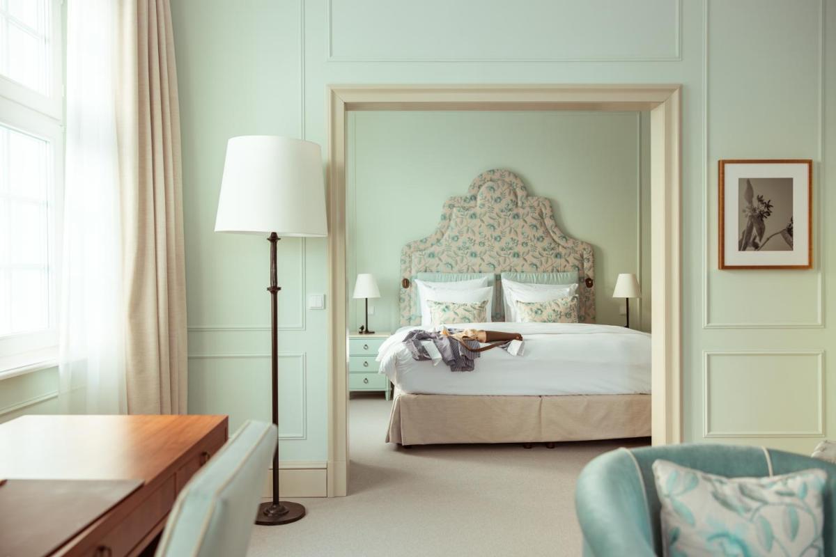 ein Schlafzimmer mit einem Bett mit einem großen Spiegel in der Unterkunft Parkhotel Quellenhof Aachen in Aachen