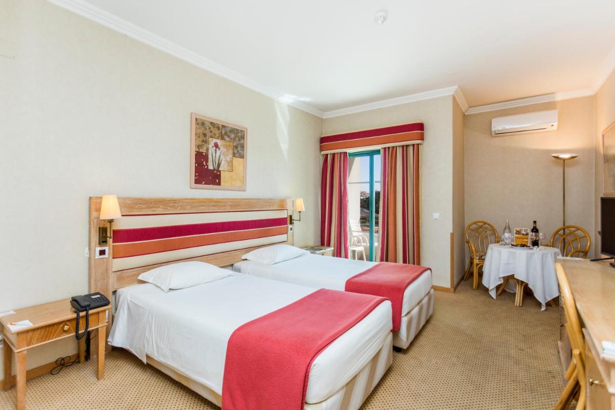 um quarto de hotel com duas camas e uma mesa em Riviera Hotel em Carcavelos mais 31 fotografias
