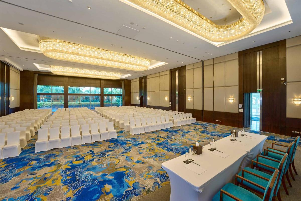 a large banquet hall with white tables and chairs at Crowne Plaza Kochi by IHG in Cochin