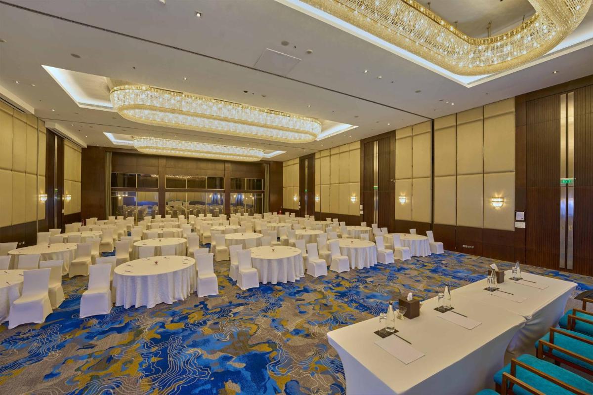 a large banquet hall with white tables and chairs at Crowne Plaza Kochi by IHG in Cochin