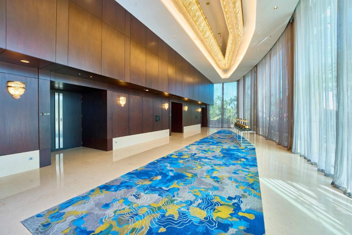 a hallway with a blue carpet in a building at Crowne Plaza Kochi by IHG in Cochin