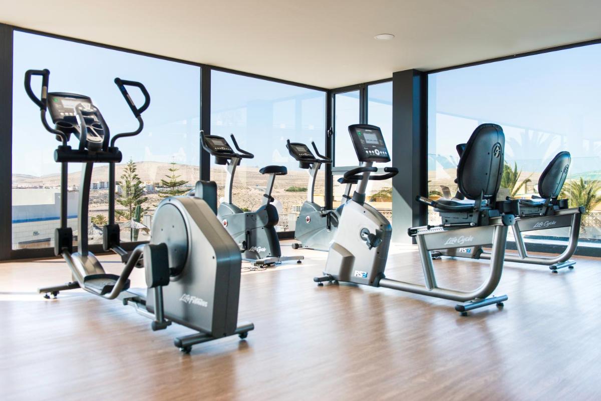 un gimnasio con una fila de cintas de correr y elípticas en Kn Hotel Matas Blancas - Solo Adultos, en Costa Calma