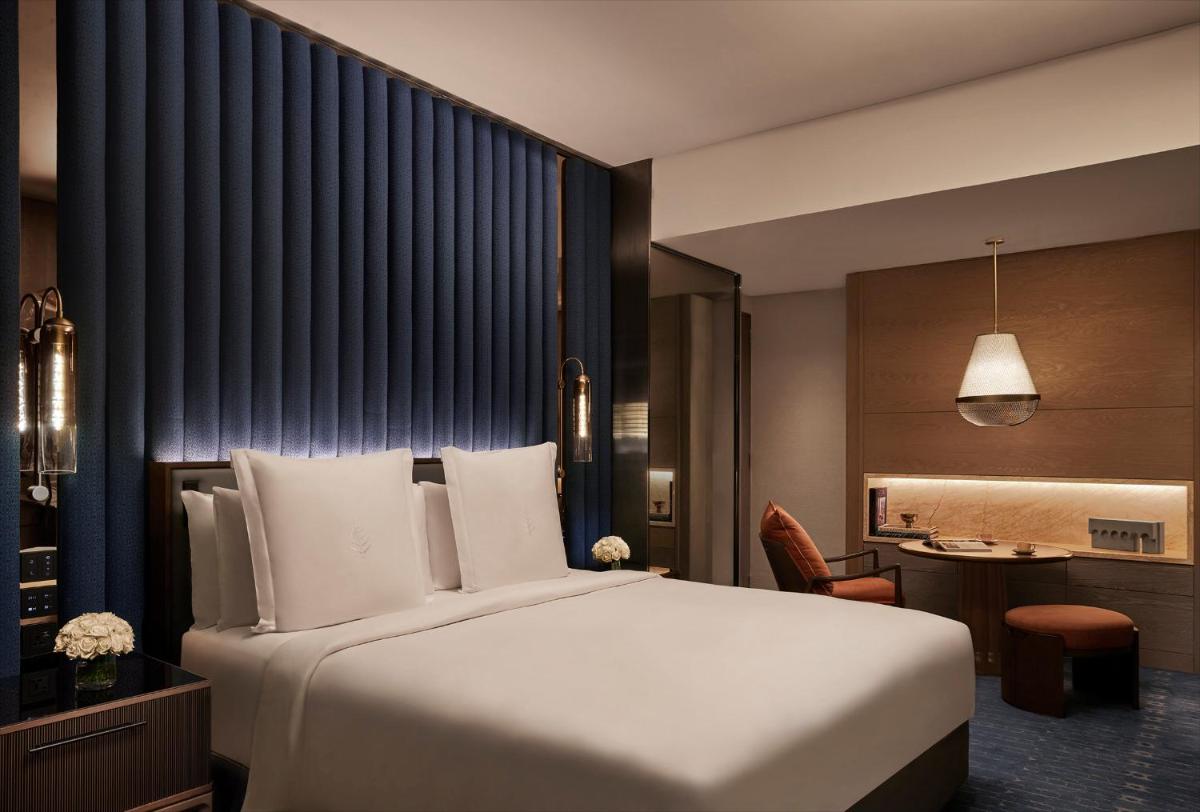a bedroom with a large white bed and a desk at Four Seasons Hotel Mumbai in Mumbai