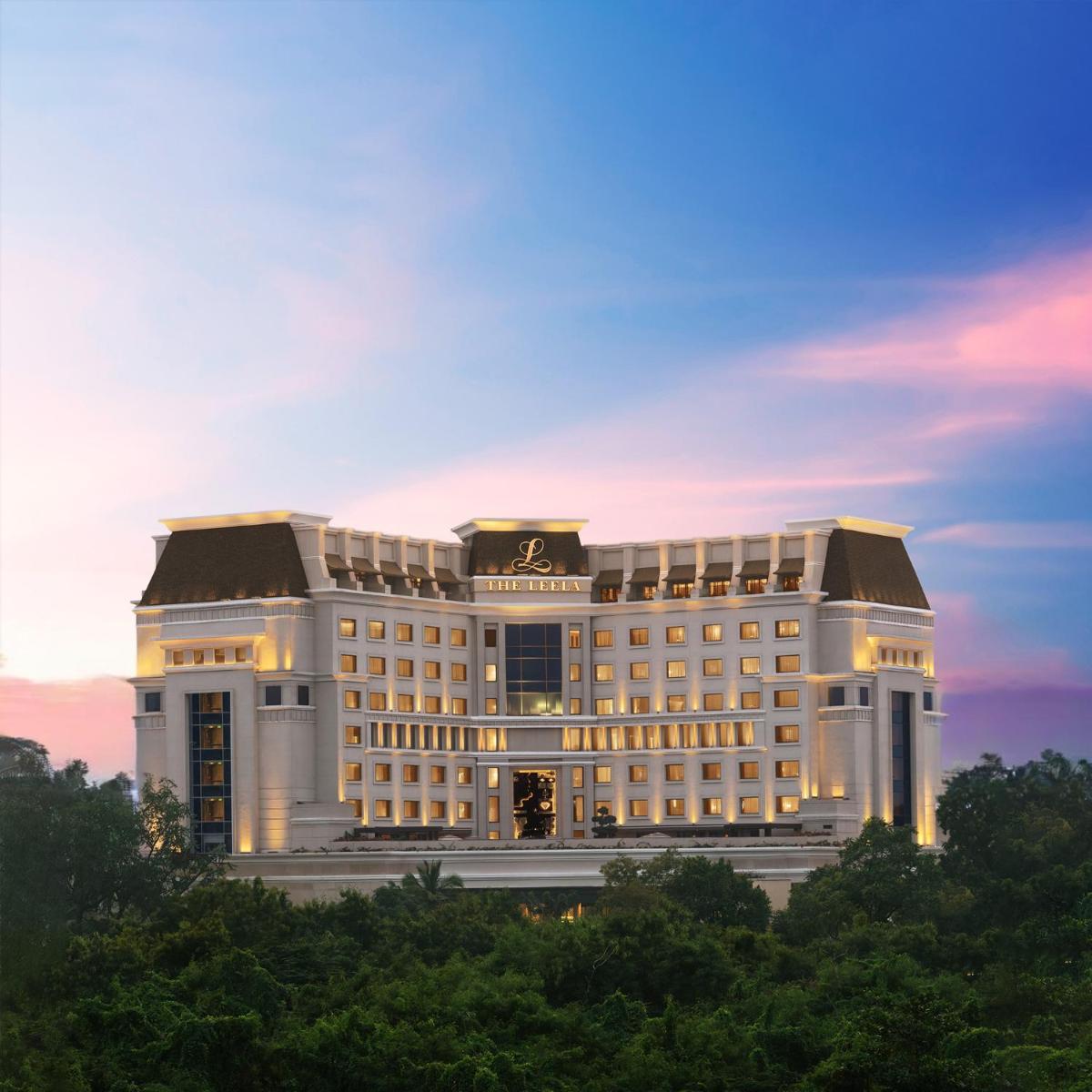 a large white building with a sunset in the background at The Leela Hyderabad Banjara Hills in Hyderabad a large white building with a sunset in the background at The Leela Hyderabad Banjara Hills in Hyderabad
